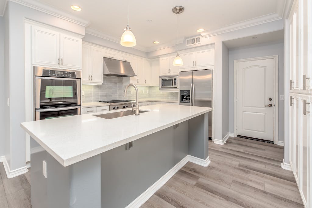 Modern kitchen interior featuring sleek white cabinetry and stainless steel appliances.