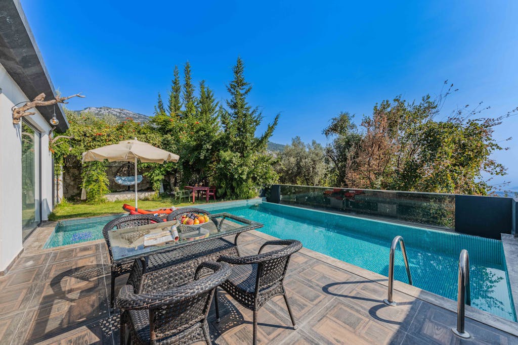 Relaxing poolside patio offering a luxurious escape with a scenic mountain view.