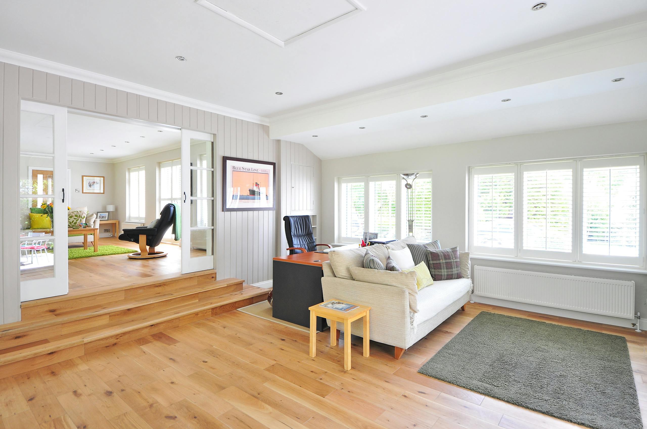 Spacious and bright modern living room with wooden floors and stylish furniture.